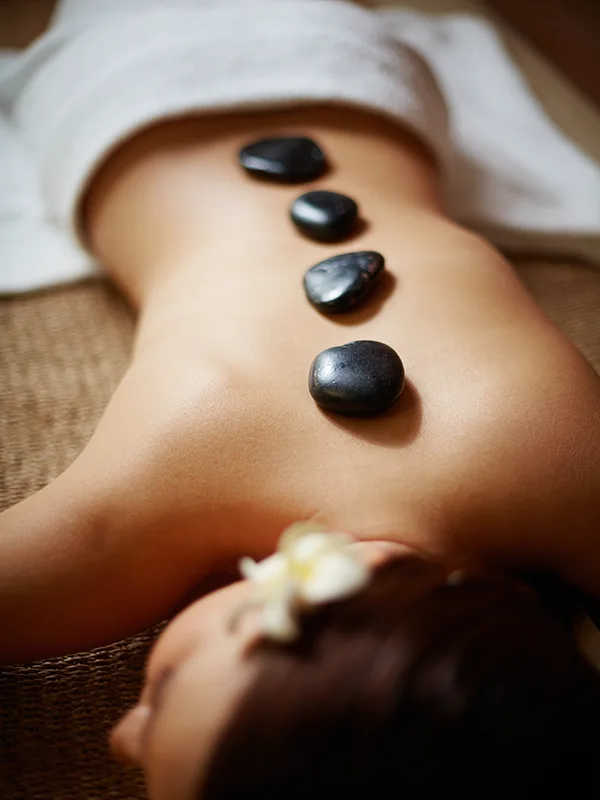 Κοπέλα ξαπλωμένη για μασάζ Hot Stones